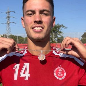 שחקן של קבוצת כדורגל הפועל תל אביב עם שרשרת תליון הפועל תל אביב