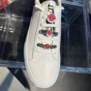 זוג תכשיטים לנעליים מכסף עם לוגו של קבוצת כדורגל הפועל תל אביב על נעל סניקרס לבנה