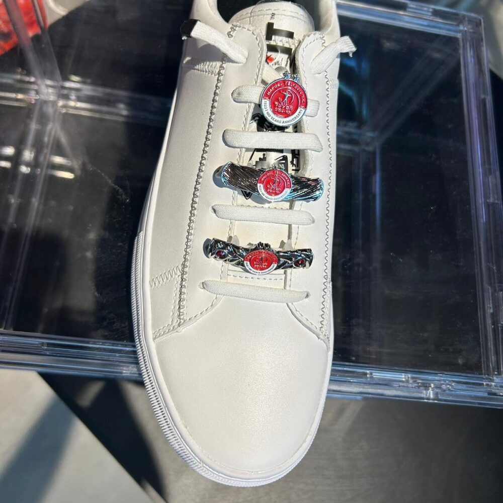 זוג תכשיטים לנעליים מכסף עם לוגו של קבוצת כדורגל הפועל תל אביב זוג תכשיטים לנעליים מכסף עם לוגו של קבוצת כדורגל הפועל תל אביב על נעל סניקרס לבנה